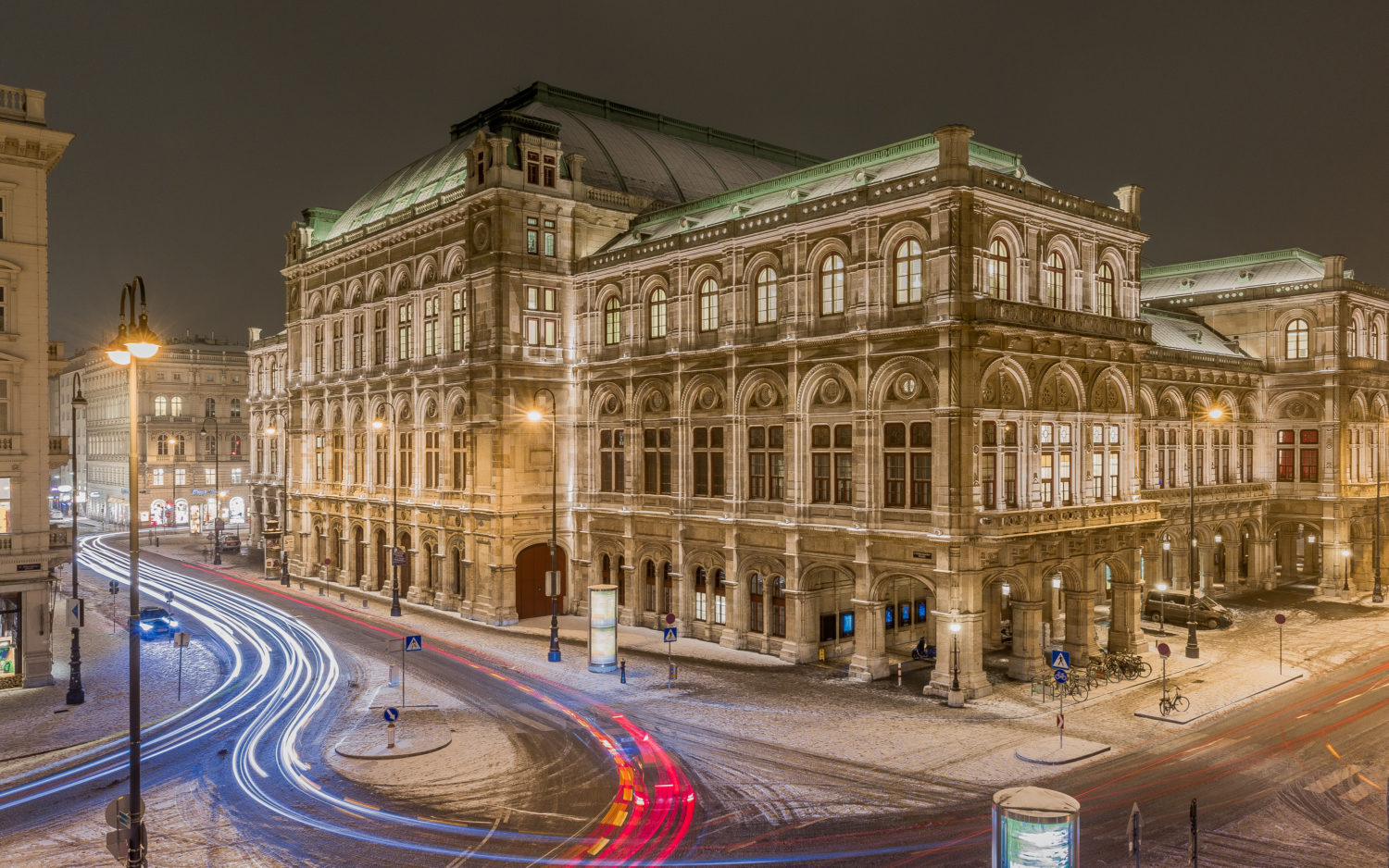 Vienna state opera in the winter night with traffic surrounding it