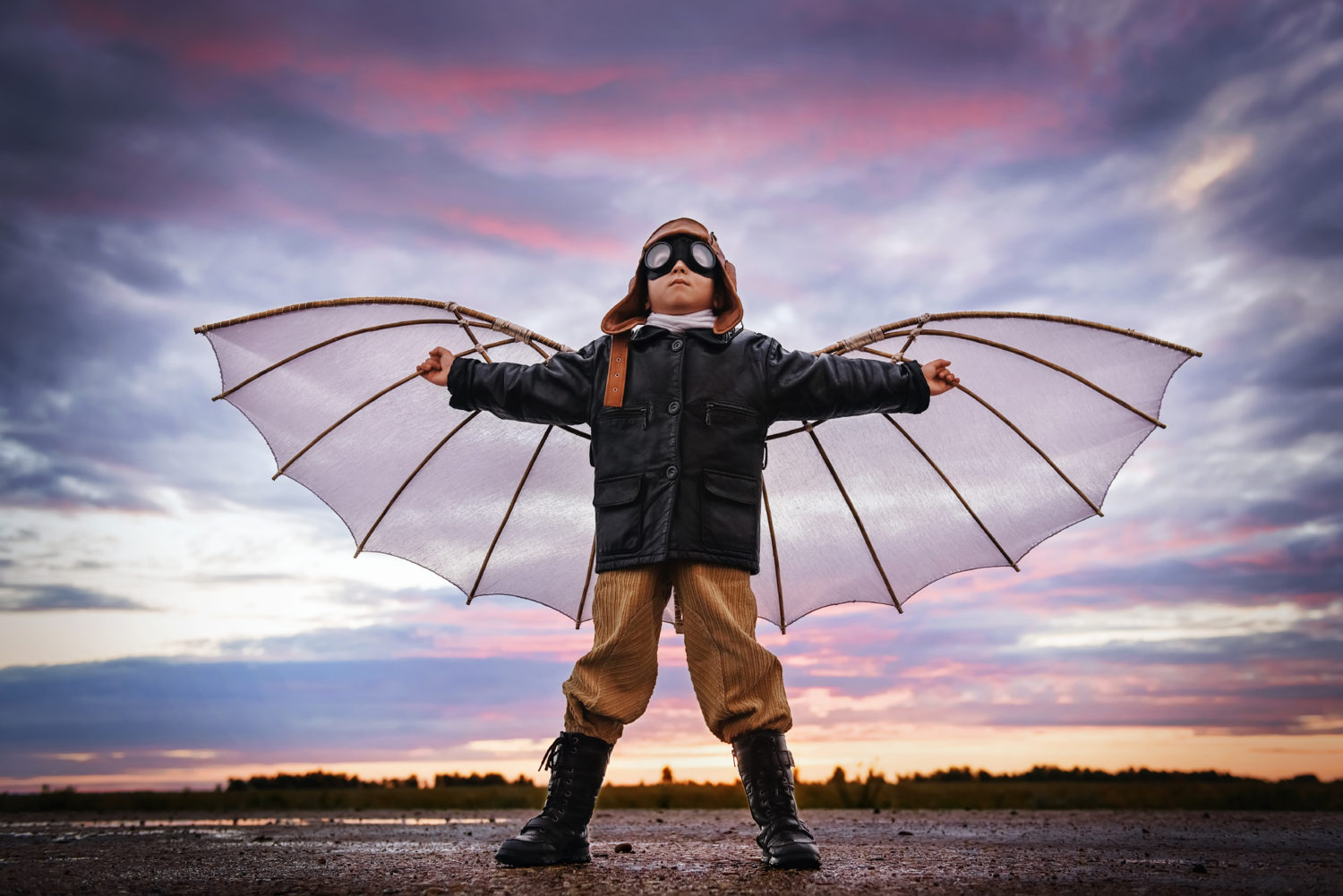 Little boy in retro pilot outfit with wings