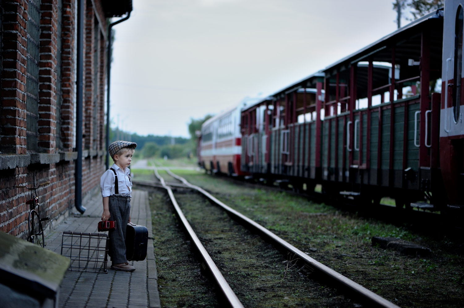 Little boy standing on an empty train platform waiting for a train from Riga to Vilnius