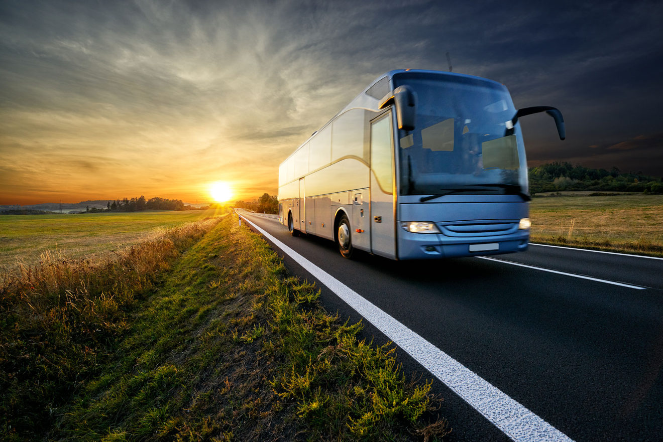 Blue bus on a country road during sunset